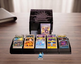 May include: A black plastic trading card display stand holding multiple rows of colorful collectible cards, positioned in front of a black Elite Trainer Box with silver text and graphics. A small blue potion icon with the text EDJ 3D is visible.