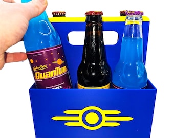 May include: A blue and yellow cardboard carrier holds three glass bottles of soda. One bottle is held by a hand. The bottles have colorful labels and bottle caps. The carrier has a logo on the front.