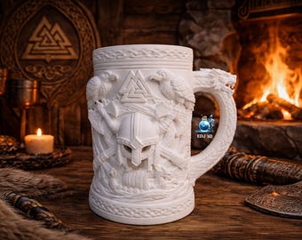 May include: White ceramic Viking-themed beer stein with intricate relief carvings of a helmet, ravens, and a dragon-shaped handle. The background includes a fireplace, candle, and wooden decor.