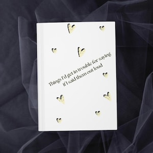May include: White notebook with the text "Things I'd get in trouble for saying if I said them out loud" and yellow heart illustrations.