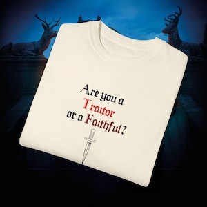May include: A white t-shirt with the text "Are you a Traitor or a Faithful?" in black and red lettering. A small dagger is printed below the text.