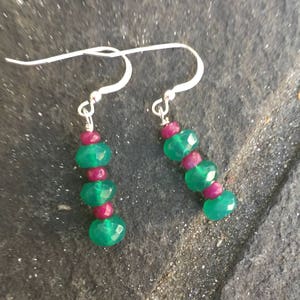 Może przedstawiać: Zestaw trzech ceramicznych misek w kolorach niebieskim, zielonym i białym. Miski mają nakrapianą glazurę i prosty design. Największa miska ma średnicę około 18 cm.