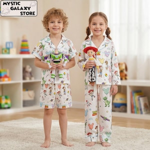Peut inclure: Deux enfants portant des pyjamas blancs assortis avec un imprimé Toy Story. Les pyjamas présentent un motif de personnages de dessins animés, de fusées et de ballons. Un enfant tient une poupée Buzz l'Éclair, l'autre une poupée Jessie. Le logo Mystic Galaxy Store est en haut à gauche.