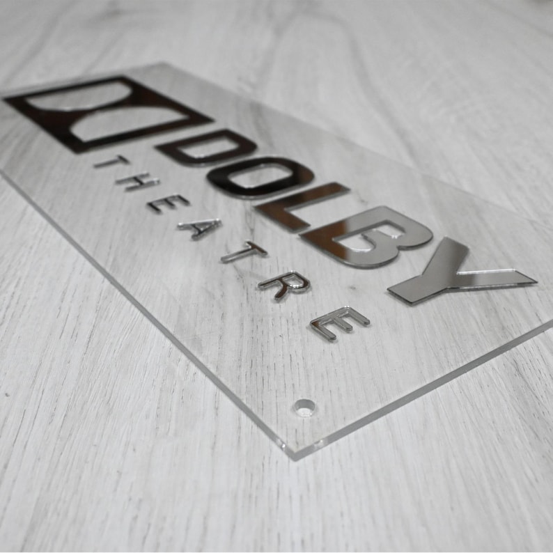 May include: A silver acrylic sign with the text "Dolby Theatre" in raised letters.