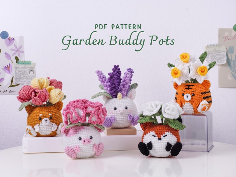 May include: A collection of crocheted animal-themed flower pots, each holding different colorful flowers. The pots are shaped like a tiger, fox, pig, unicorn, and dog. The text "PDF PATTERN Garden Buddy Pots" is visible.