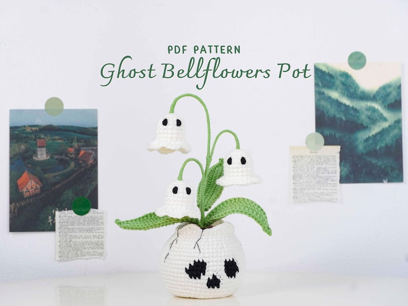 May include: A crocheted Ghost Bellflowers Pot, a whimsical Halloween decoration. The white pot has a skull design, and the plant features white ghost-shaped flowers with black eyes and green stems and leaves. The text "PDF PATTERN Ghost Bellflowers Pot" is visible.