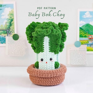 May include: A crochet plush of a baby bok choy with dark green ruffled leaves and a light green stalk, featuring black bead eyes and a small red mouth. The plush sits in a brown crochet pot. Text above reads PDF PATTERN Baby Bok Choy.