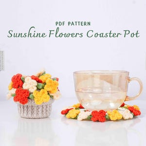 May include: A crochet coaster pot with a floral design, featuring red, yellow, and white flowers. A glass teacup sits on a matching coaster. The text "Sunshine Flowers Coaster Pot" is displayed above the objects.