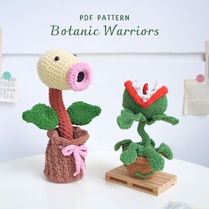 May include: PDF pattern for crocheting two plant-like characters, a yellow and pink one with a brown pot and a green one with a red mouth and a brown pot. The pattern is titled "Botanic Warriors".