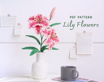 May include: A PDF pattern for crocheting lily flowers. The image shows a bouquet of pink and green crocheted lilies in a white vase. The text "PDF PATTERN Lily Flowers" is displayed above the bouquet.