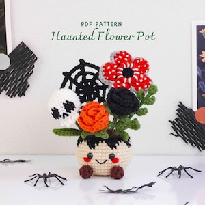 Pode incluir: Um vaso de flores em crochê com base bege, um rosto sorridente e dois pés castanhos. Contém um crânio branco, uma teia de aranha preta, uma rosa laranja, uma rosa preta e uma flor vermelha e branca com folhas verdes. Texto: PDF PATTERN Haunted Flower Pot.