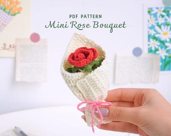 May include: A crocheted mini rose bouquet with a red rose and green leaves, wrapped in cream-colored yarn and tied with pink yarn. The text "PDF PATTERN Mini Rose Bouquet" is visible in the background.
