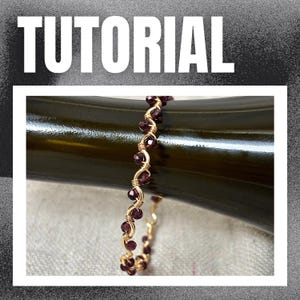 May include: A gold-colored wire bracelet with dark red beads is wrapped around a dark green bottle. The bracelet is made with a twisted wire design. The word "TUTORIAL" is written in white block letters at the top of the image.