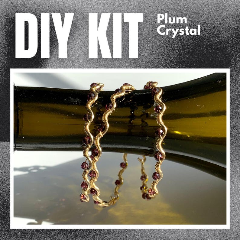 May include: DIY Kit with Plum Crystal. Two gold-colored, wire-wrapped bracelets with plum-colored crystals are draped over a dark green bottle. The bracelets have a wavy design. The text "DIY KIT" is in large white letters.