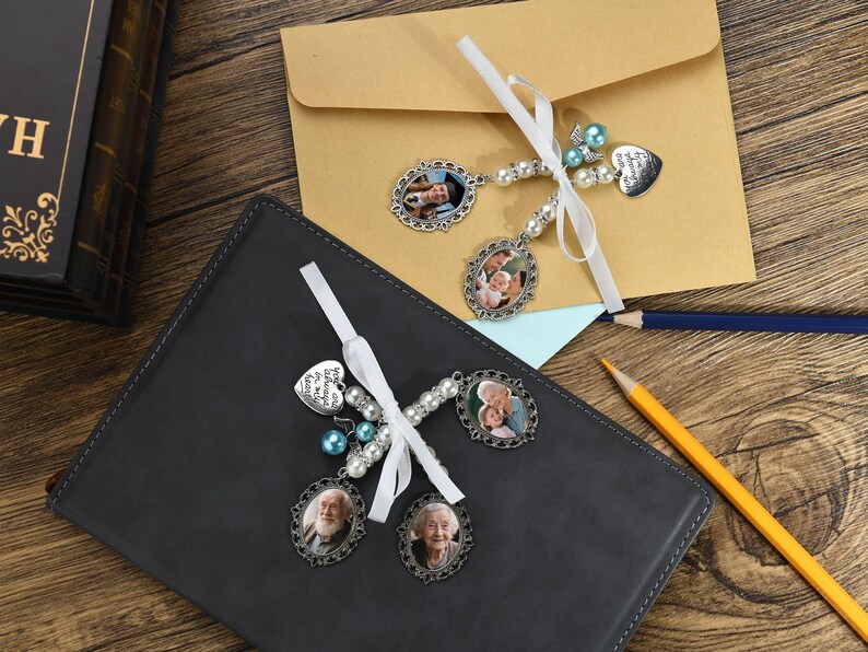 May include: Two white ribbon bookmarks with silver charms and beads. The charms feature photos of couples and the text "In loving memory of our angel".