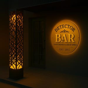 May include: Exterior of a bar at night. A tall, geometric, illuminated pillar is on the left. A round, illuminated sign reads "Detector Bar" with the text "Good Drinks & Great Times" and "Est. 2017".