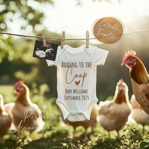 Peut inclure: Une grenouill&egrave;re blanche pour b&eacute;b&eacute; avec le texte "Adding to the Coop" en lettres brunes. Un graphique de poussin brun est au-dessus du texte. La grenouill&egrave;re porte &eacute;galement le texte "Baby Williams September 2023" en lettres brunes. La grenouill&egrave;re est suspendue &agrave; une corde &agrave; linge avec une image d'&eacute;chographie floue en arri&egrave;re-plan. Il y a des poulets au premier plan.