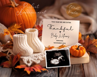 Könnte beinhalten: Eine Dankeskarten-Baby-Ankündigungskarte mit weißem Hintergrund. Die Karte zeigt eine handschriftliche Nachricht mit dem Text "Dieses Jahr sind wir besonders dankbar Baby Williams kommt im November 2024 an". Auf der Karte befinden sich zwei kleine weiße gestrickte Babyschuhe, ein Kürbis und ein Ultraschallbild.