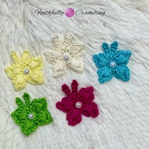 May include: Five handmade crochet flower appliques in various colors: yellow, cream, turquoise, green, and magenta. Each flower features a pearl bead center. The text "Faithfully Crocheting" is in the background.