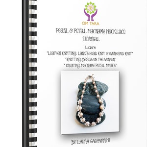 May include: A tutorial book titled "Pearl & Petal Macramé Necklace" with a spiral binding. The cover features a necklace made of pearls and petal-shaped macramé, resting on dark stones. The book's text includes "Learn" and instructions.
