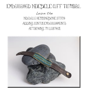 May include: A tutorial on how to make a beaded Ndebele cuff bracelet. The tutorial covers the herringbone stitch, adding center embellishments, and attaching the beaded piece to leather. The image shows a finished cuff bracelet on a pile of rocks.