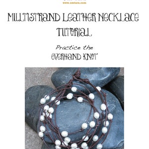 Peut inclure: Un collier en cuir multi-brins avec des perles blanches, présenté sur un fond de pierres grises. Le collier est noué avec un nœud coulant. Le texte "Pratiquez le nœud coulant" est écrit sous l'image.