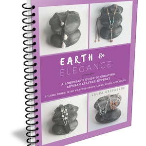 May include: A purple book titled "Earth & Elegance: A Bohemian's Guide to Creating Artisan Leather Jewellery" with a subtitle "Volume Three: Wire Wrapped Drops, Links, Binds, & Dangles" by Laura Gasparrini. The cover features three photos of leather jewellery on stacked stones.