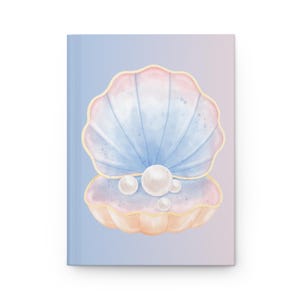 Puede incluir: Un diario de tapa dura con una ilustración de acuarela de una concha abierta con perlas. La concha es en tonos de azul, rosa y melocotón, con un contorno dorado. El fondo es un degradado de azul y rosa.