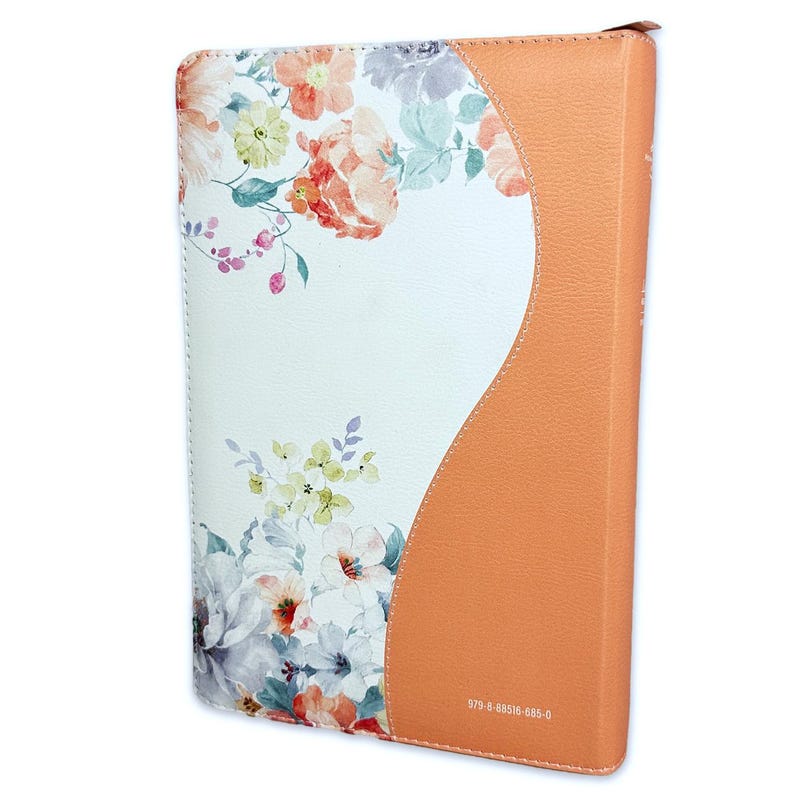 May include: A white and orange leather-bound journal with a floral design. The journal has a curved spine and a floral pattern on the front cover. The back cover is solid orange leather. The text "978-8-85516-085-0" is printed on the back cover.