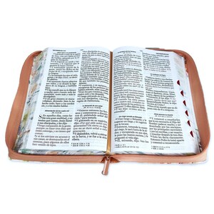May include: An open Bible with a brown leather cover and a floral pattern. The pages are open to the book of Mark, chapters 6 and 7. The text is in Spanish.
