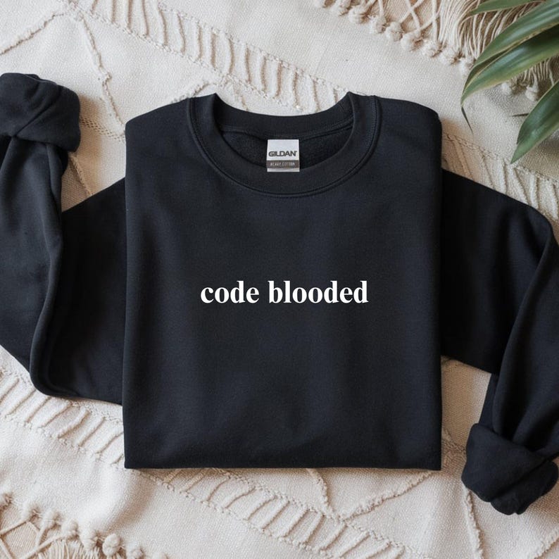 May include: Black crewneck sweatshirt with the text "code blooded" in white. The sweatshirt is made of a soft material and has a classic, casual style. The Gildan brand tag is visible on the back of the neck.