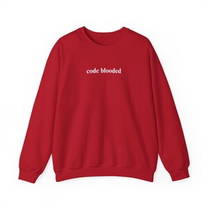 May include: A red sweatshirt with the text "code blooded" in white, centered on the chest. The long-sleeved top is made of a soft material and is suitable for casual wear. The crew neck design is visible.