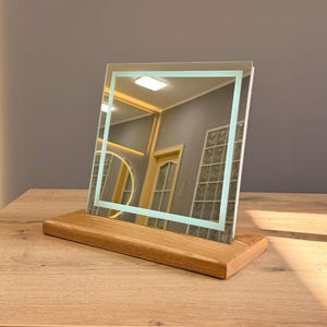 Minimalist tabletop mirror with wooden stand in modern interior lighting