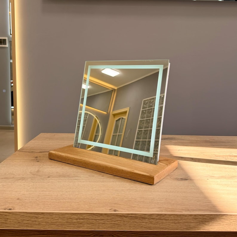 Minimalist tabletop mirror with wooden stand in modern interior lighting