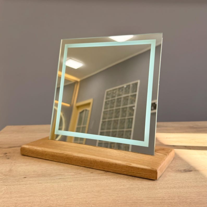 Elegant tabletop vanity mirror with warm LED reflection and wooden holder base