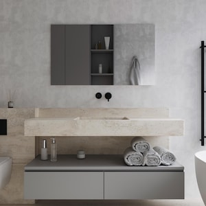 May include: A modern bathroom vanity with a light stone countertop and a gray cabinet. Above, a gray medicine cabinet with a mirror and a towel. Rolled gray towels and toiletries are on the vanity.