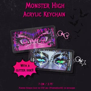 May include: Two acrylic Monster High keychains with stylized eye designs. One has pink and purple eyes, the other blue and green. The keychains are 7 cm long and have a glitter side. The text "Monster High Acrylic Keychain" is at the top.