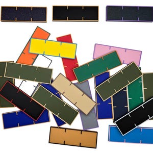 May include: A collection of colorful rectangular tiles with different patterns and colors, including black, white, green, blue, yellow, red, orange, pink, and brown. The tiles are arranged in a random pattern on a white background.