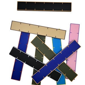 May include: A set of eight colorful rulers with black markings. The rulers are made of a flexible material and are approximately 12 inches long.