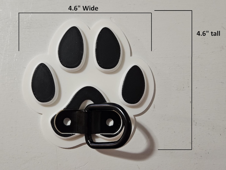 May include: White plastic paw print with black paw pads and a black metal D-ring. The paw print is 4.6 inches wide and 4.6 inches tall.