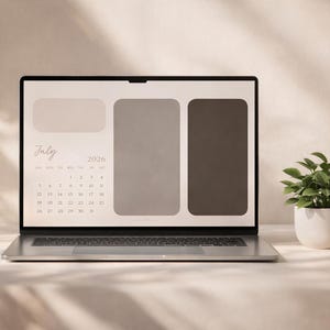 May include: A silver laptop displays a desktop calendar for July 2026 with a neutral color scheme. A small potted plant with green leaves sits to the right. The laptop is on a white surface.