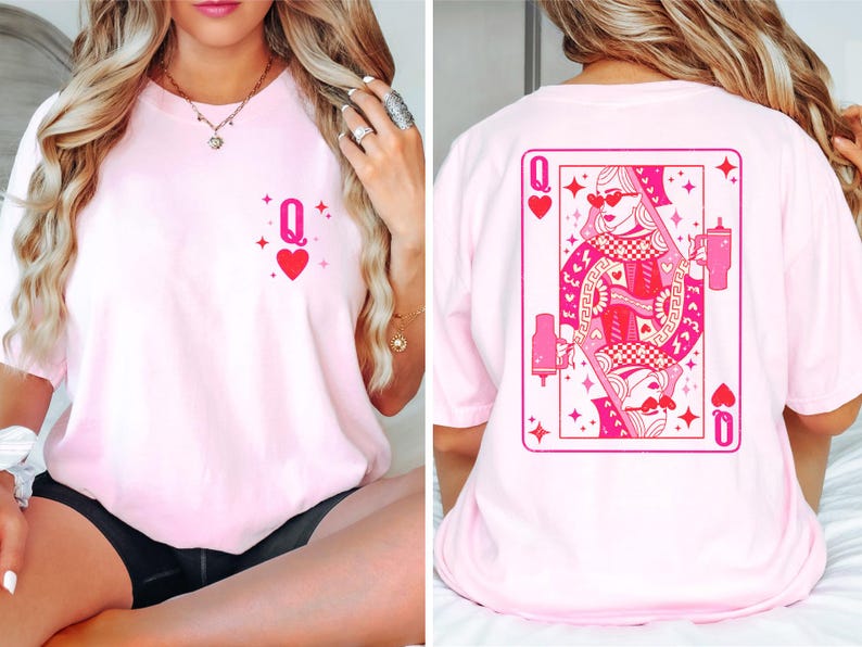 Puede incluir: Camiseta rosa con un gr&aacute;fico de una carta de reina de corazones en la parte posterior y un peque&ntilde;o gr&aacute;fico de reina de corazones en la parte delantera.