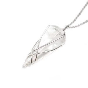 May include: A silver chain necklace with a clear quartz crystal pendant encased in a silver wire cage.