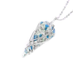 May include: A silver chain necklace with a blue and white stone pendant. The stone is wrapped in silver wire.