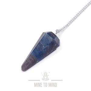 May include: A blue and grey crystal pendulum on a silver chain. The pendulum is faceted and has a pointed tip.