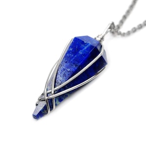 May include: A silver chain necklace with a blue lapis lazuli pendant wrapped in silver wire.
