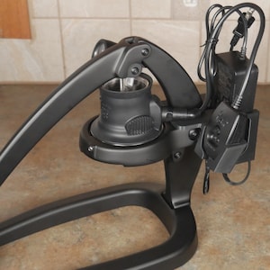 May include: A black electric citrus juicer with a lever arm and a base. The juicer has a cord and a power adapter.