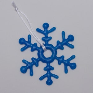 May include: A blue glass snowflake ornament with a white string for hanging.