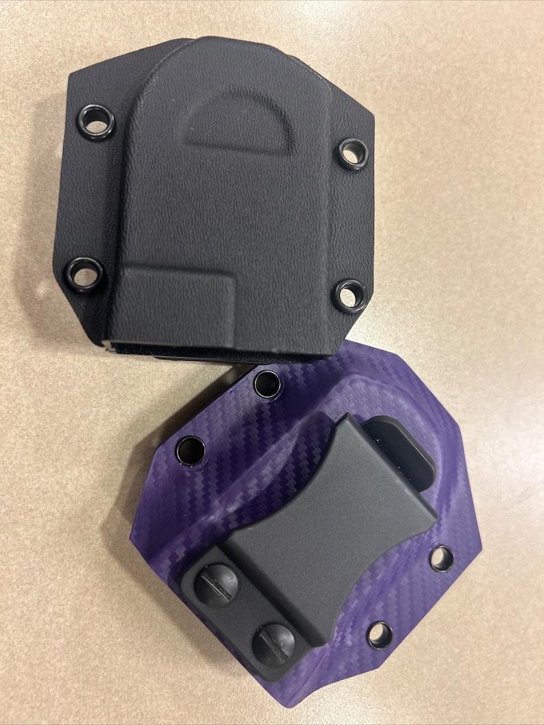 May include: Two holsters for a knife or other small tool. One is black and the other is purple with a carbon fiber pattern.