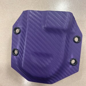 May include: Purple leather holster with a carbon fiber pattern and black metal eyelets.